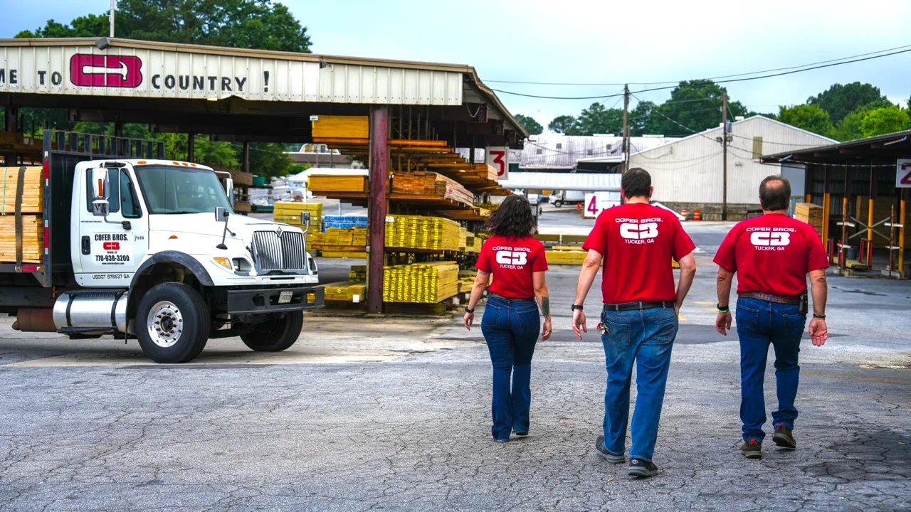 The Cofer Bros. team in red shirts walking into the lumberyard, photographed by Grit Blueprint