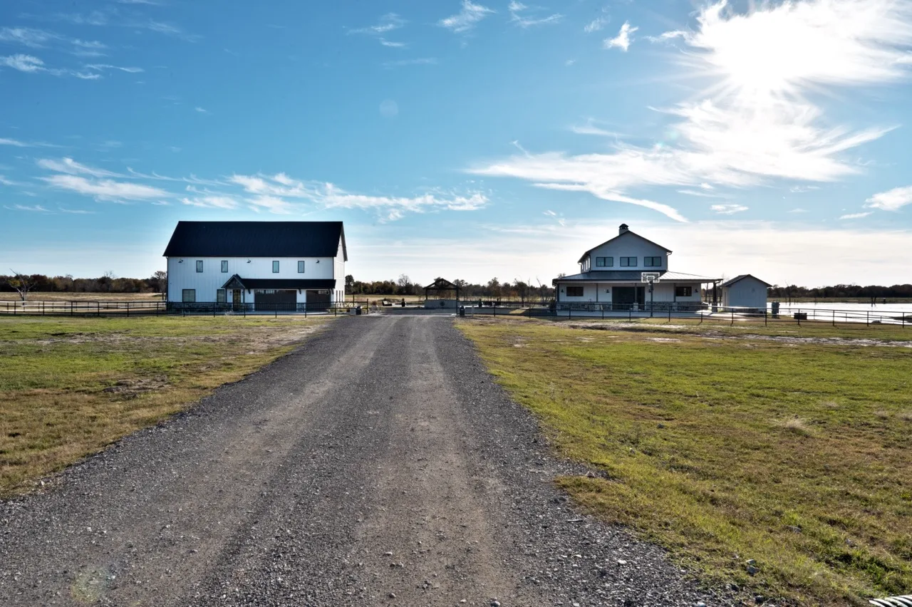Two white barndominiums on the ranch property, photographed by Grit Blueprint