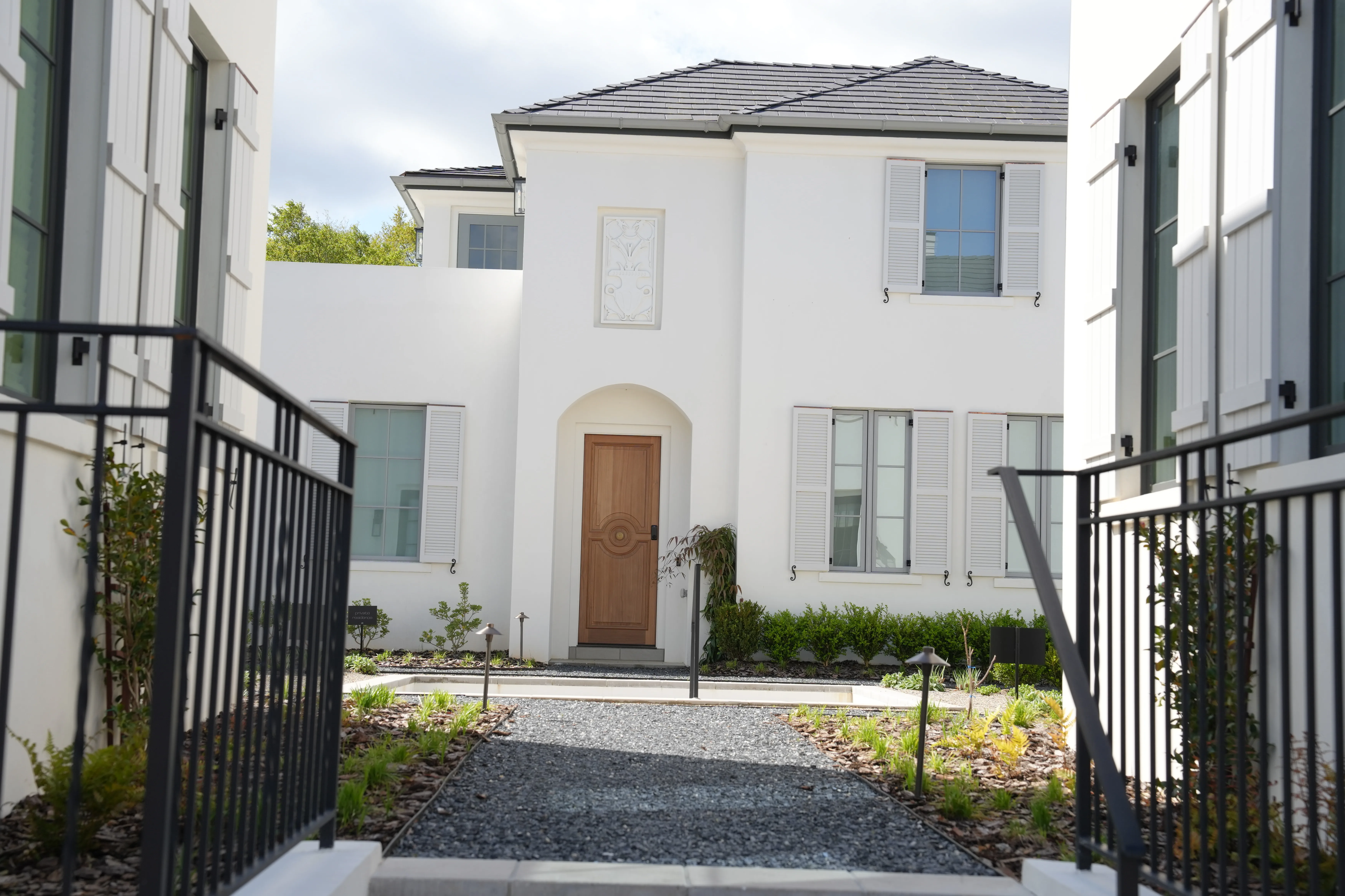 White stucco home with louvered shutters and a wood entry door at Trilith, photographed by Grit Blueprint