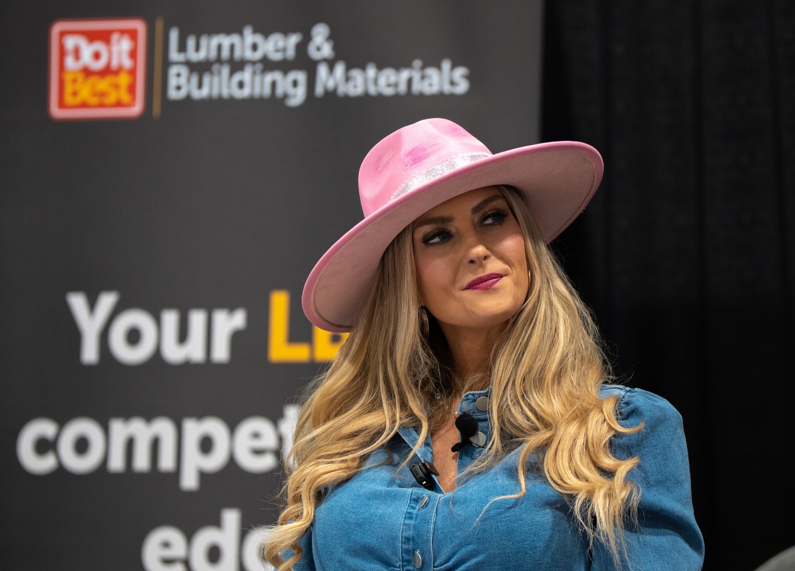 Stefanie Couch speaking on stage at a Do it Best Lumber and Building Materials event