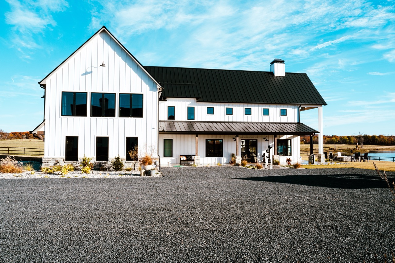 Lakeside modern barndominium with board-and-batten siding and a black standing-seam roof, built by Harrill Construction in Canton, Texas, photographed by Grit Blueprint