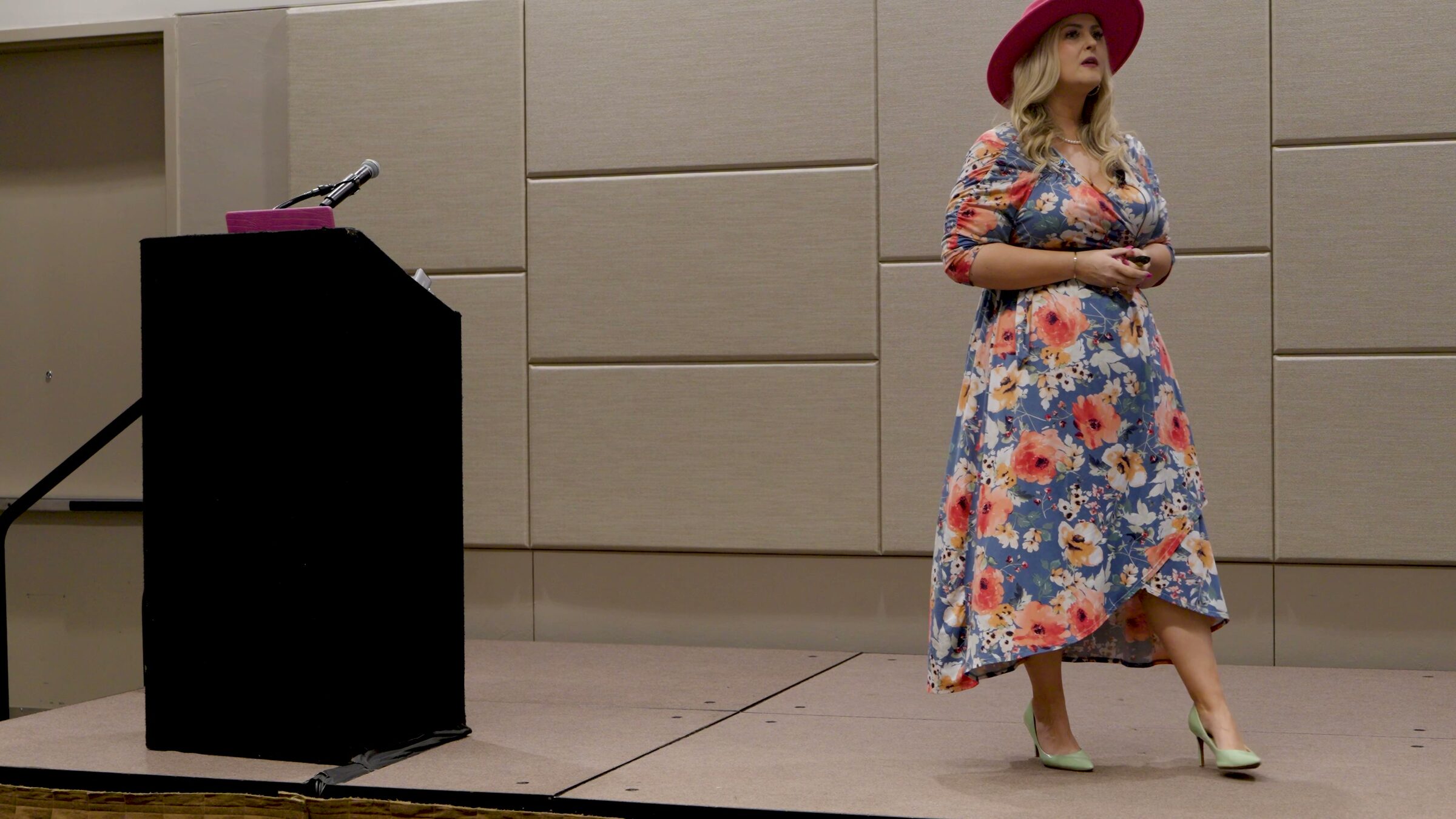 Stefanie Couch walking across a stage beside a black podium during her session